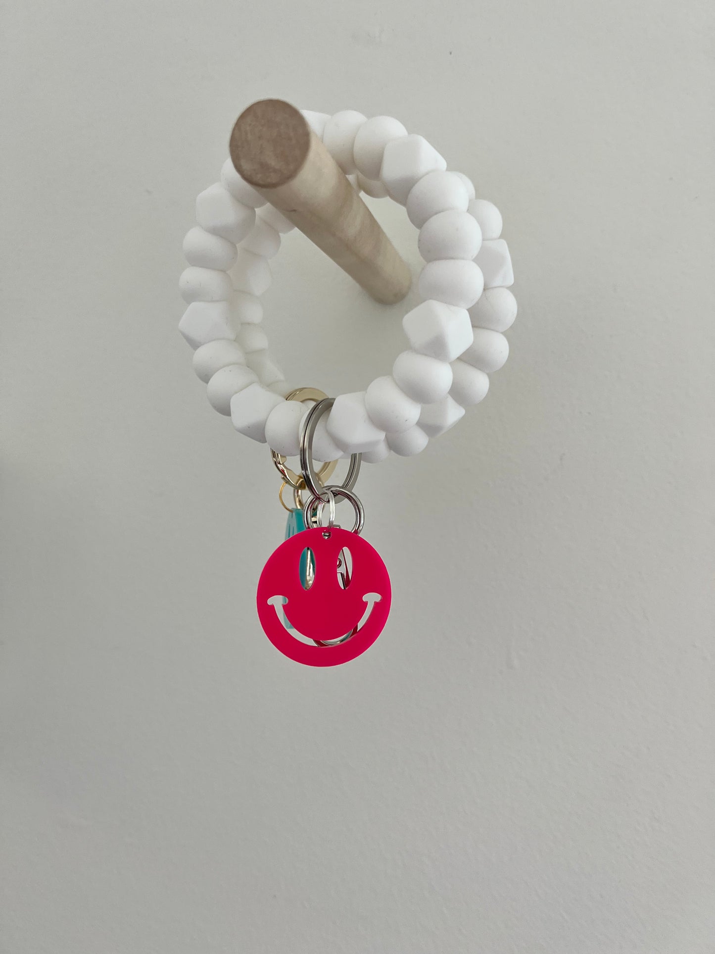 all white bracelet keychain with neon smiley