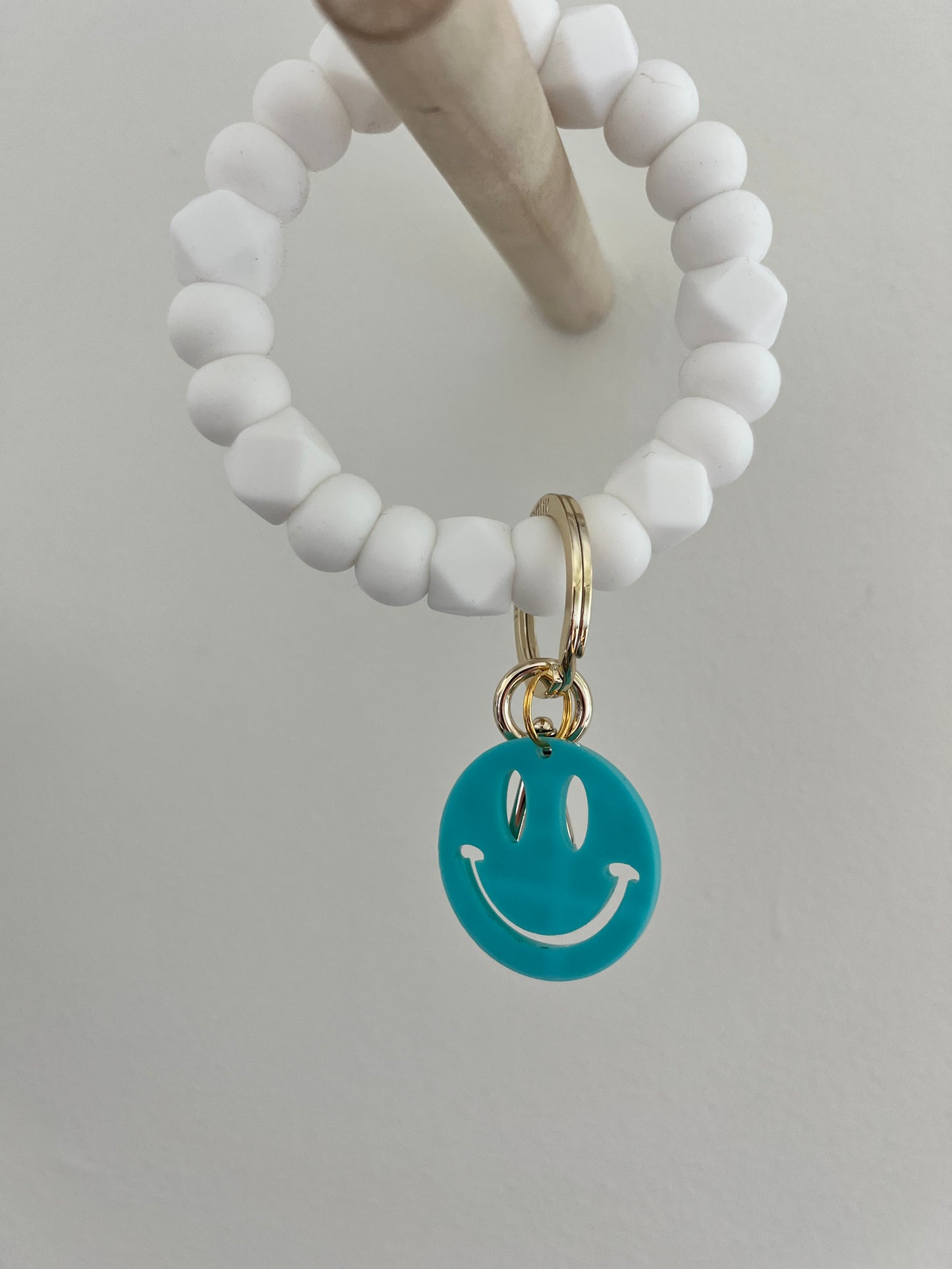 all white bracelet keychain with neon smiley