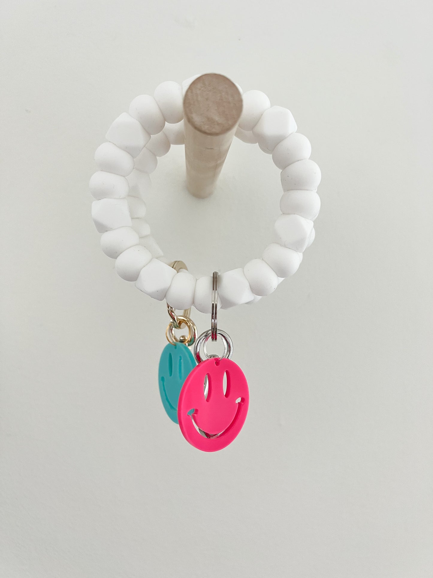 all white bracelet keychain with neon smiley